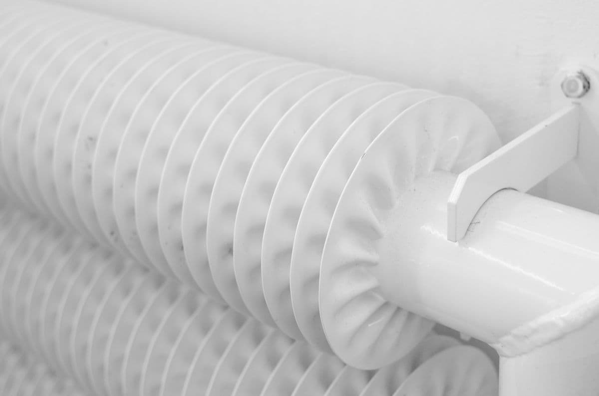 Radiateur en acier raccordé à ses tubes, en pose de chauffage.