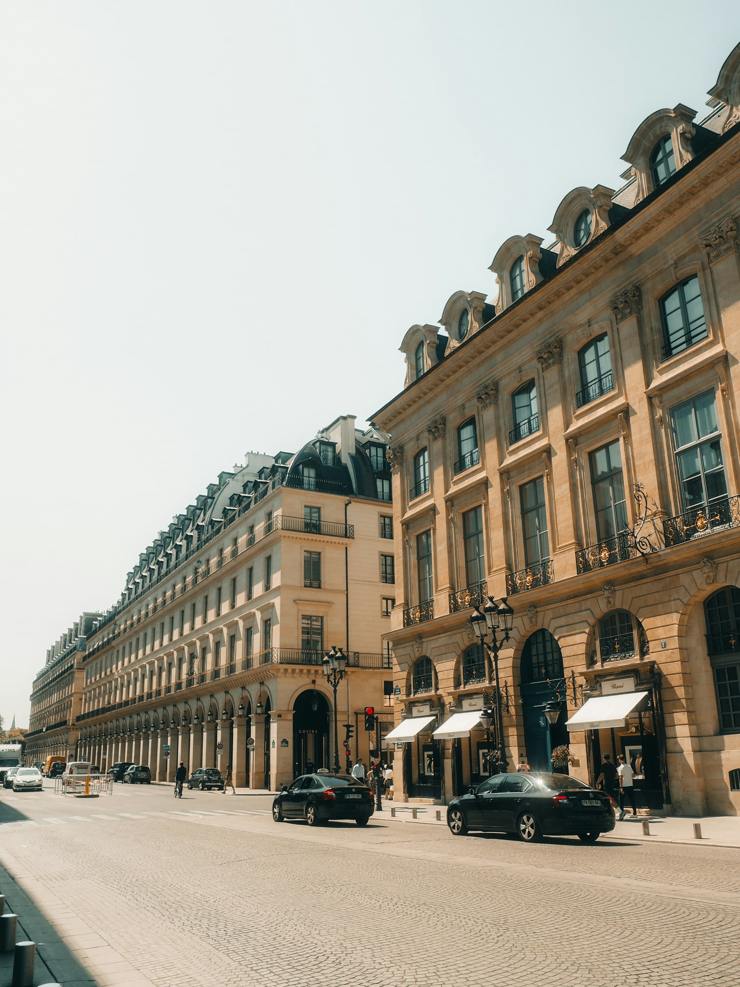 Enfilade de façades parisiennes ouvragées en pierre de taille et enduit, balcons en fer forgé.