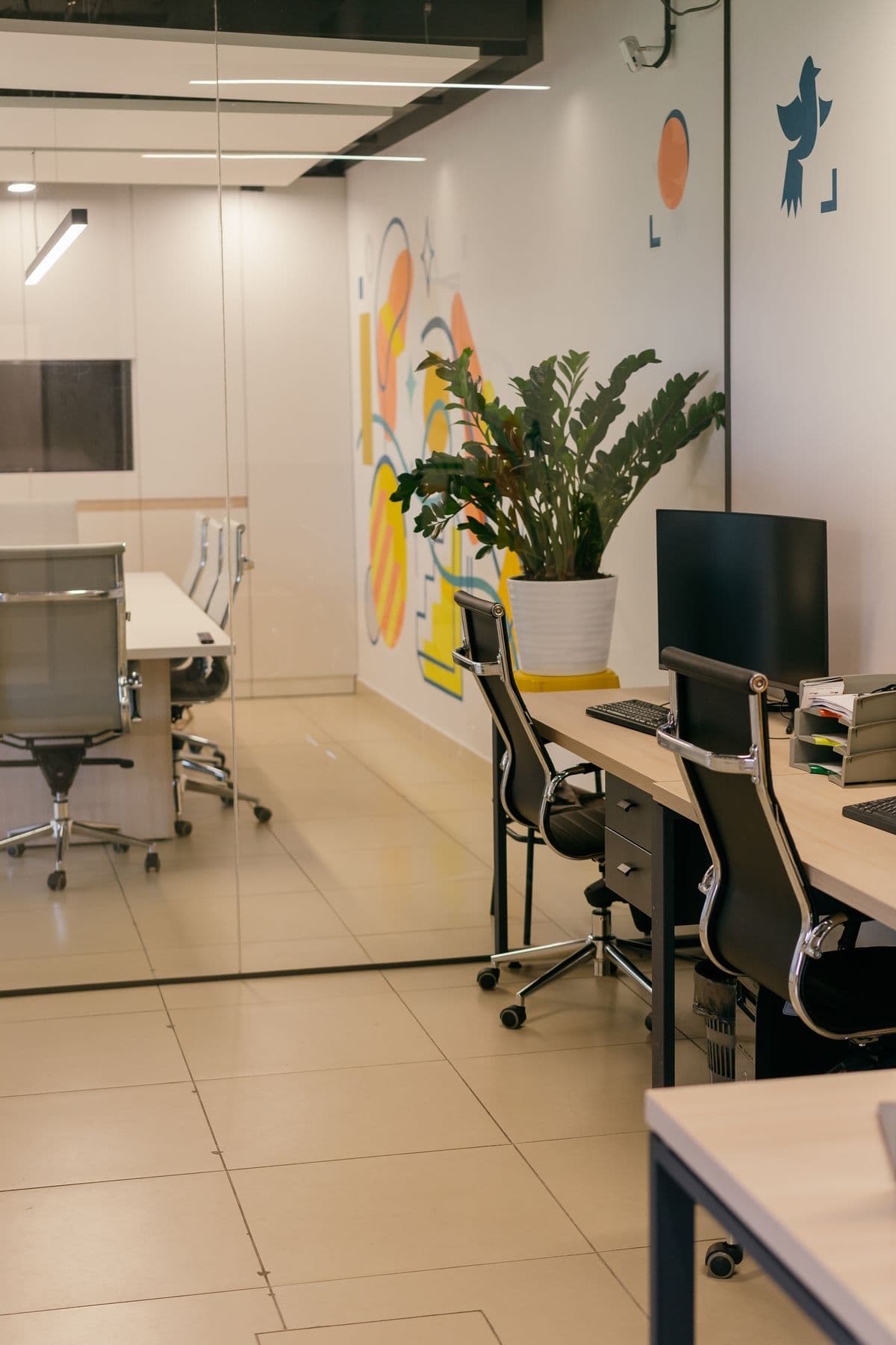 Open space lumineux : postes de travail, plantes et cloison graphique.