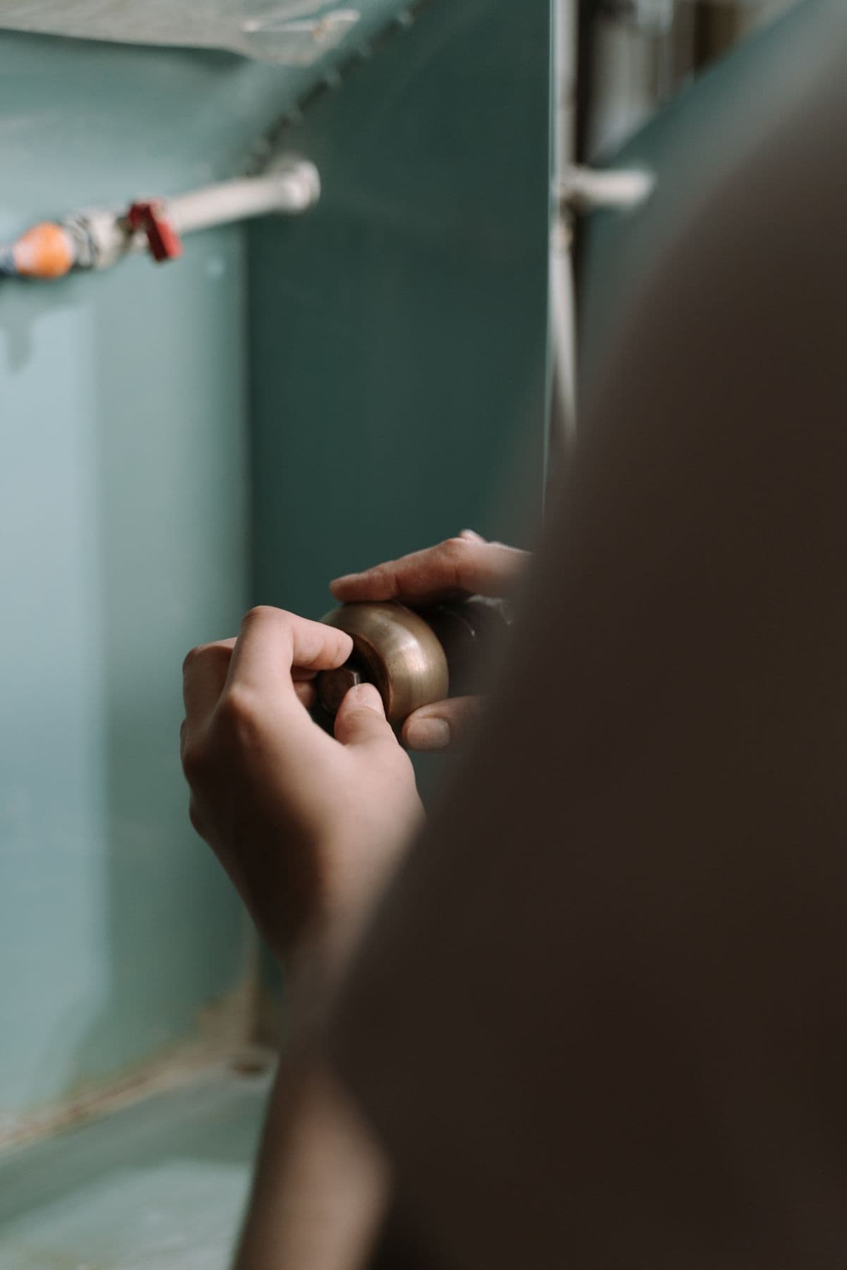 Raccordement d'évacuation sous un évier, siphon et tuyaux.