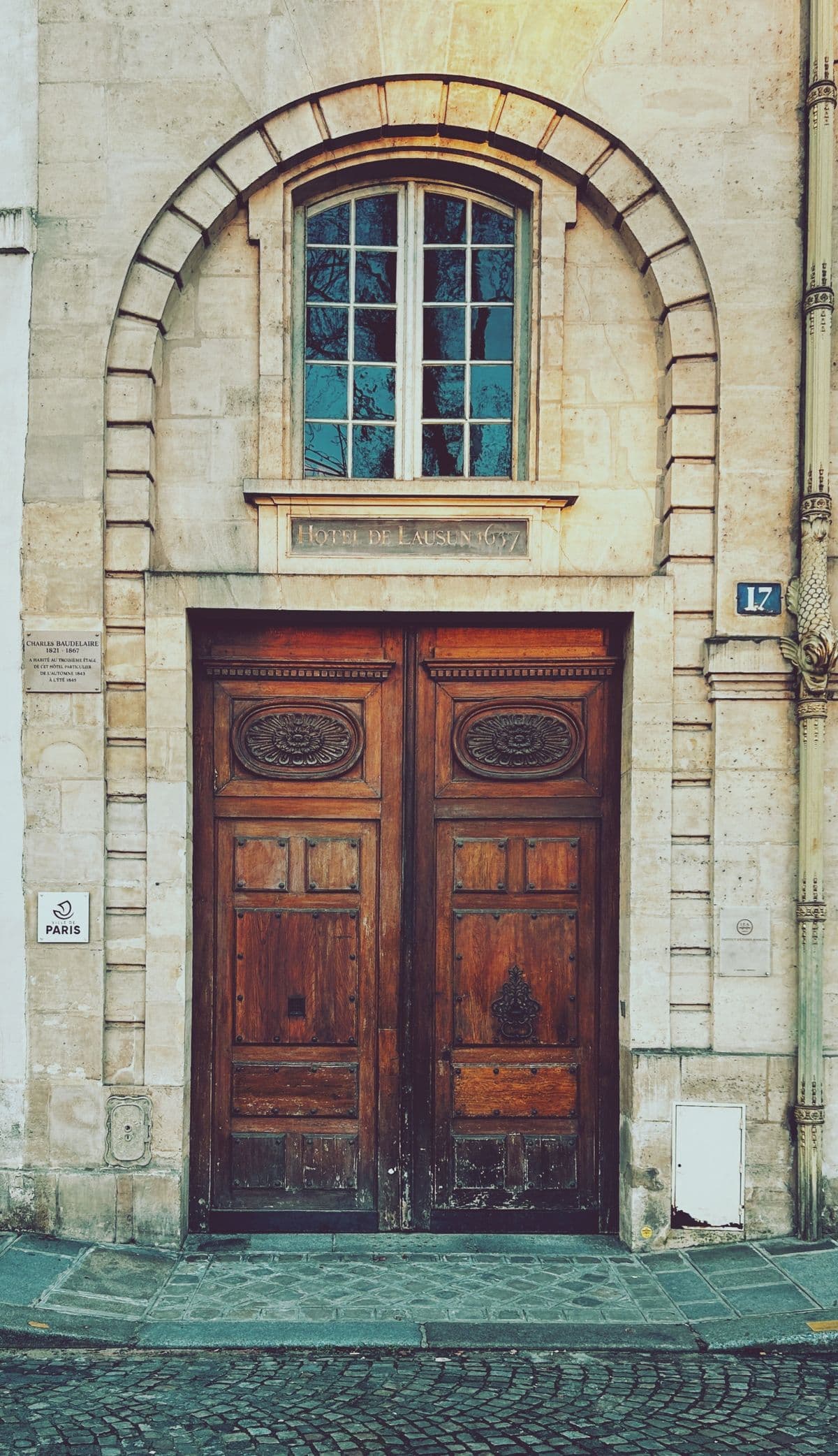 Porte cochère en bois d'une façade parisienne ancienne, à panneaux moulurés.