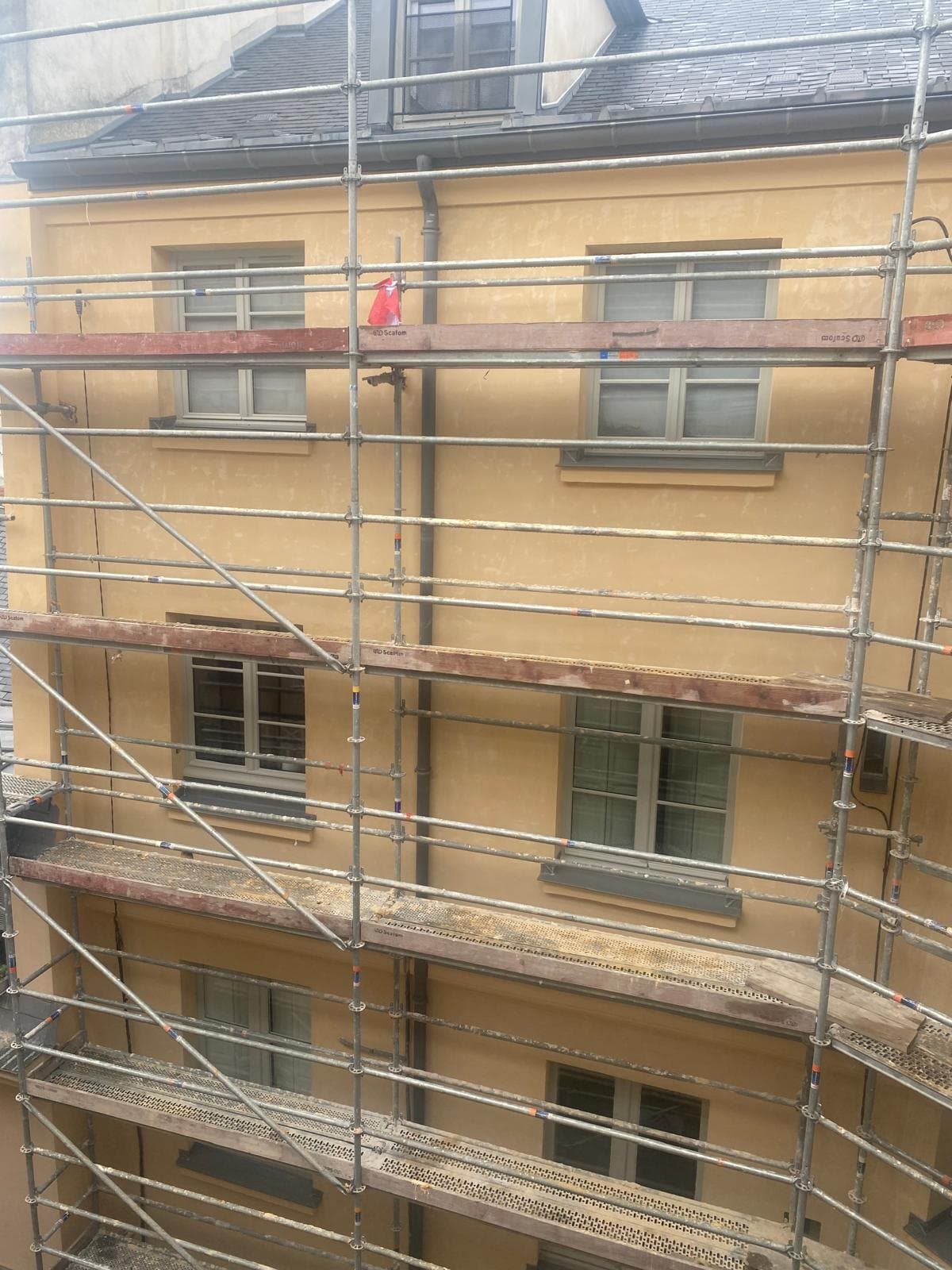 Façade d'immeuble sous échafaudage, en cours de ravalement.