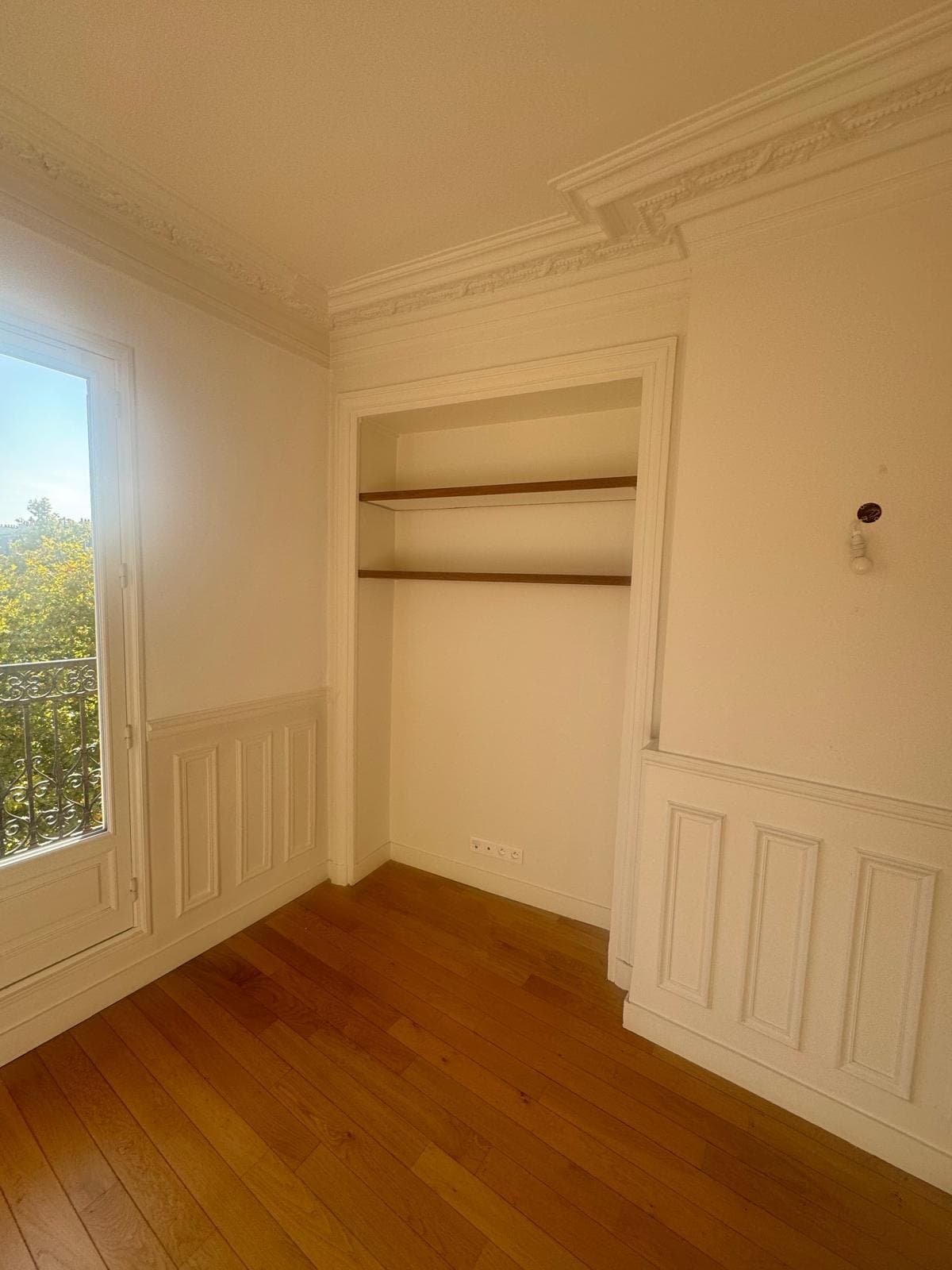 Pièce rénovée à boiseries et parquet.