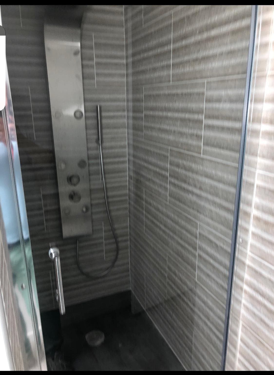 Douche à l'italienne carrelée, paroi vitrée.