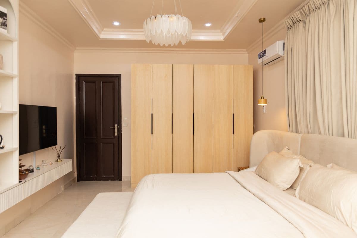 Chambre ouverte sur un dressing en bois : penderies et rangements intégrés.